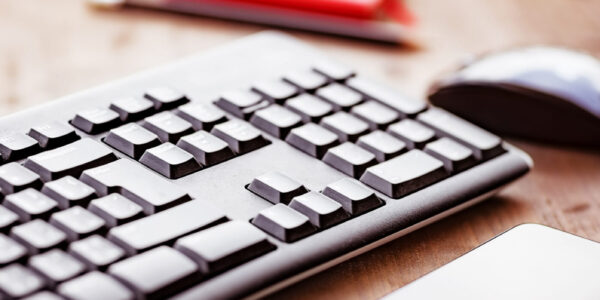 Desktop in the office, computer keyboard, pc mouse and mobile phone on the wooden table, work place